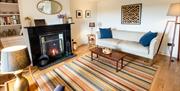 Living room with fireplace lit at Wayside Cottage 1637 in Whitbeck, Lake District