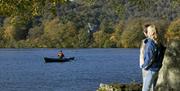 Visitors Watching a Canoe on Windermere in the Lake District, Cumbria