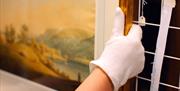 Employee handling artwork with gloves at an Exclusive Experience at Wordsworth Grasmere in the Lake District, Cumbria ©Copyright Gareth Gardner 2019