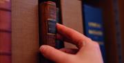 Visitor taking a book off a bookshelf at an Exclusive Experience at Wordsworth Grasmere in the Lake District, Cumbria ©Copyright Gareth Gardner 2019