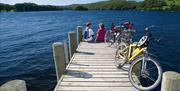 Cyclists at the End of a Lake Pier on a Cycling Holiday in the Lake District, Cumbria from The Carter Company