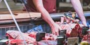 Chris Russell with beef at the butchers counter at Cranstons Orton Grange Food Hall near Carlisle, Cumbria