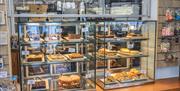 Baked goods available in a glass display at The Bluebird Cafe in Coniston, Lake District
