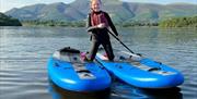 Child with stand-up paddleboards from Newlands Adventure Centre in the Lake District, Cumbria