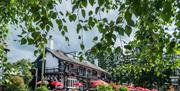 Exterior and lush plants in the summer at Pooley Bridge Inn in the Lake District, Cumbria