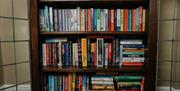 Fully stocked bookshelf at The Pheasant Lodge near Grange-over-Sands, Cumbria