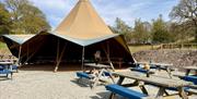 Tipi with benches at Graythwaite Adventure in the Lake District, Cumbria