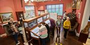 Visitors looking at exhibits at Keswick Museum in Keswick, Lake District