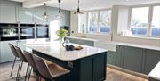 Kitchen and breakfast bar at Moss Foot Holiday Home in Firbank, Cumbria