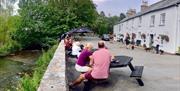 Outdoor seating with river view at The King's Head in Ravenstonedale, Cumbria