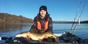 Visitor posing with fish caught on a fishing trip with West Pennine Angling Solutions in the Lake District, Cumbria