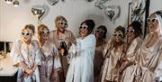 Bride and bridesmaids celebrate while getting ready at The Halston in Carlisle, Cumbria © Kayley Greenall