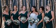 Bride and bridesmaids pose for a photo at The Halston in Carlisle, Cumbria © Beth Faulder Photography