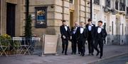 Groom and groomsmen pose for a photo in front of The Halston in Carlisle, Cumbria