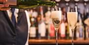 Staff pours sparkling wine at The Borrowdale Hotel in Borrowdale, Lake District