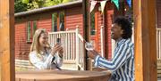 People enjoying drinks on an outdoor terrace at White Cross Bay Holiday Park in Windermere, Lake District