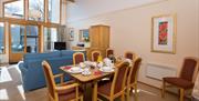 Living area and dining table inside a lodge at Keswick Bridge in Keswick, Lake District