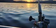 Fishing pole with a sunset backdrop on a fishing trip with West Pennine Angling Solutions in the Lake District, Cumbria