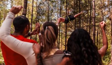 Group of adult friends watching someone go down a zipline