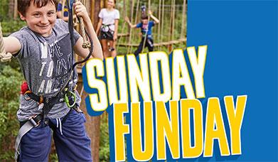 Young boy smiles at the camera while climbing at Go Ape Grizedale, text reads "Sunday Funday"