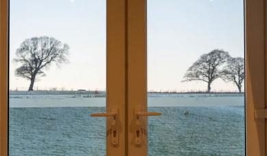 View through glass doors over a frosty field from The Fleece at Ruleholme