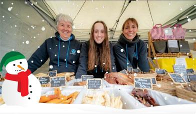 The Doggy Deli team smiles in front of a display of natural dog treats