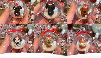 Christmas baubles with miniature clay animal figurines and snow