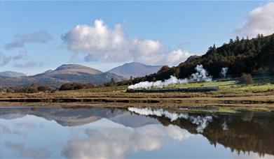 Ravenglass and Eskdale Railway Train with a scenic mountain backdrop and lake reflection © Mark Fielding
