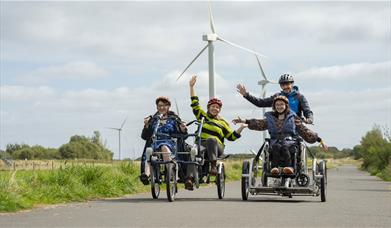 Visitors on hired cycles and accessible cycle at Watchtree Nature Reserve in Wiggonby, Cumbria