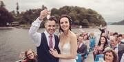Bridal Couple and Wedding Guests on a Windermere Lake Cruises Vessel with a Scenic Backdrop in the Lake District, Cumbria