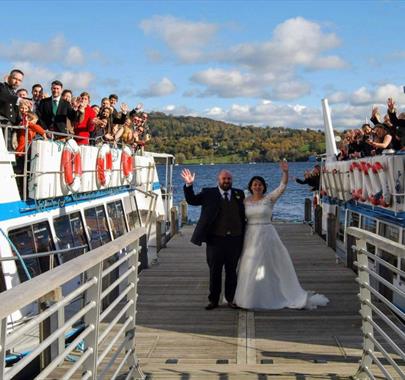 Bridal Couple and Wedding Guests on a Jetty and Windermere Lake Cruises Vessels in the Lake District, Cumbria