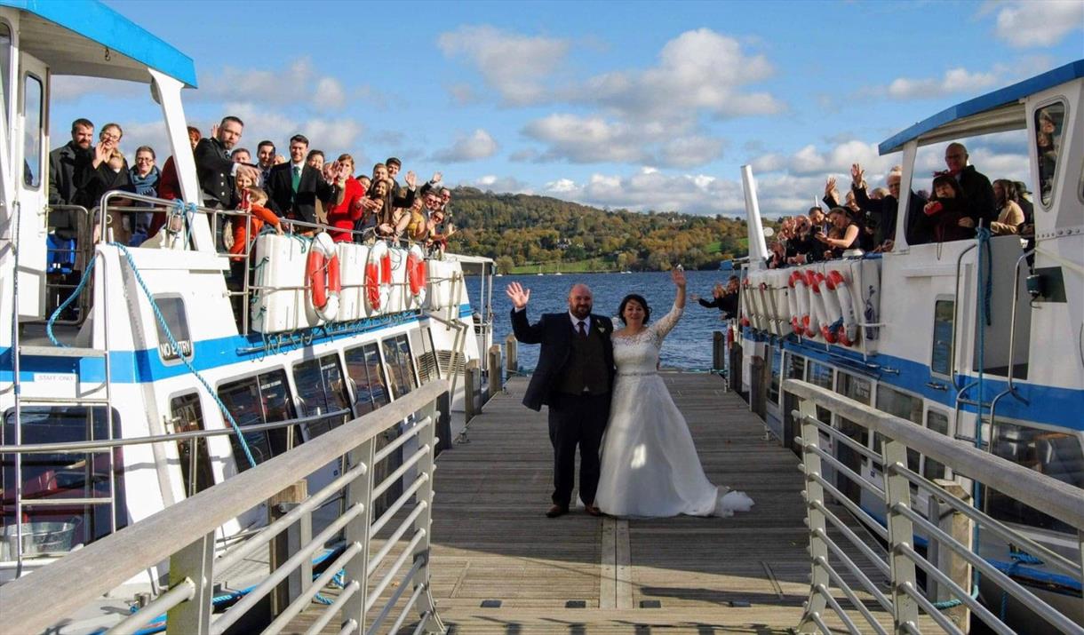 Bridal Couple and Wedding Guests on a Jetty and Windermere Lake Cruises Vessels in the Lake District, Cumbria