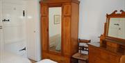 Twin bedroom with solid wood wardrobe and dressing table in No. 3 Main Street Cottage in Elterwater, Lake District