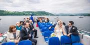 Wedding Guests on a Windermere Lake Cruises Vessel with a Scenic Backdrop in the Lake District, Cumbria