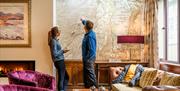 Visitors Looking at a Map on the Wall at The Borrowdale Hotel in Borrowdale, Lake District