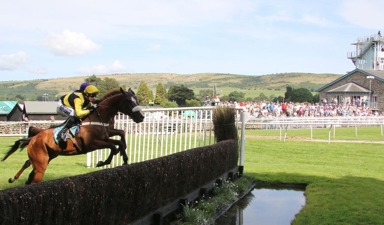 Horses Jumping at Summer Jump Horse Racing at Cartmel Racecourse in Cartmel, Cumbria