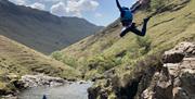 Visitors Jumping at Esk Ghyll with Crags Adventures in the Lake District, Cumbria