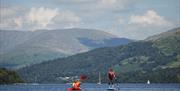 Visitors Kayaking and Paddleboarding at Windermere Canoe Kayak in the Lake District, Cumbria