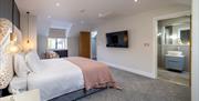 Double Bedroom with Wall-Mounted TV and Door to Ensuite at Hoglet Cottage in Dalston, Cumbria