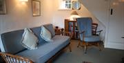 Lounge tastefully furnished with Ercol furniture with door to the stairs in Wistaria Cottage in Elterwater, Lake District