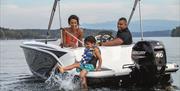 Family with Child Playing in a Lake on a Boat from Freedom Boat Club Windermere in Bowness-on-Windermere, Lake District