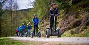 Visitors Segway Uphill at Go Ape in Grizedale Forest in the Lake District, Cumbria