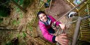 Visitor Smiling Up at the Camera, Climbing at Go Ape in Grizedale Forest in the Lake District, Cumbria