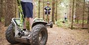 Visitors on Segways on a Forest Path at Go Ape in Whinlatter Forest Park in Braithwaite, Lake District