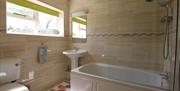 Bath with a Shower Head, Toilet, and Sink in a Bathroom at Heather View in Threlkeld, Lake District