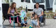 Family Sitting on a Touring Pitch at Hollins Farm Holiday Park in Far Arnside, Cumbria