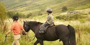 Child Riding a Horse near Limefitt Holiday Park in Troutbeck, Lake District