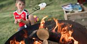 Child Toasting a Marshmallow over a Fire at Moss Howe Farm Campsite in Witherslack, Lake District