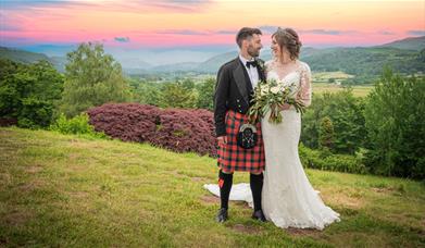Bride and Groom Posing with Scenery at Muncaster Castle in Ravenglass, Lake District
