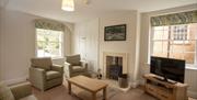 Lounge Area at Netherby Hall in Longtown, Cumbria, with TV and Wood Burner